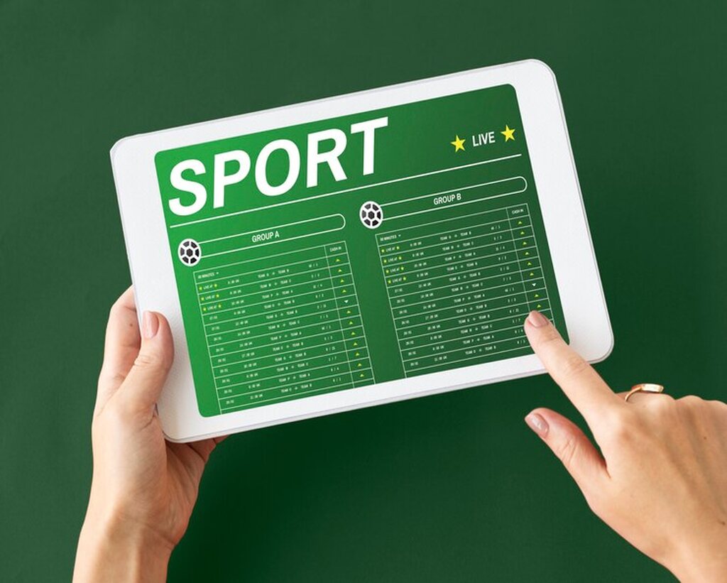 Apostadora que usou robos em apostas esportivas confere os dados em um tablet