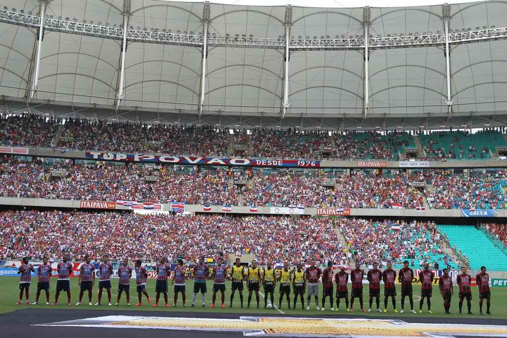 Jogadores do Fortaleza enfileirados ao lado da equipe de arbitragem e do time adversário, em estádio lotado, antes do jogo.