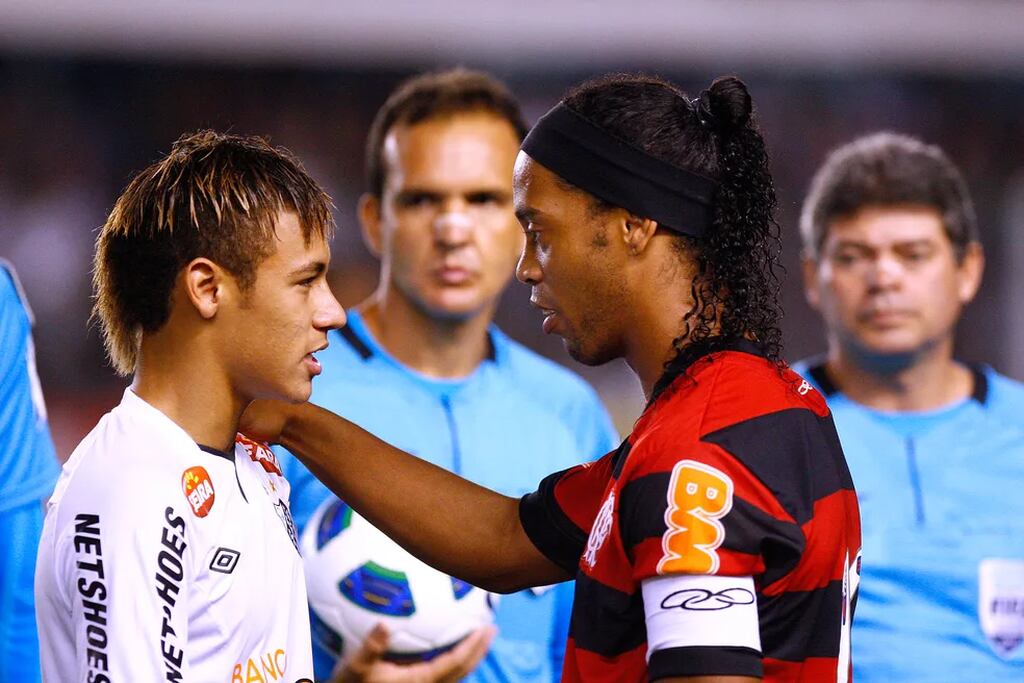 Neymar, com uniforme do Santos, conversando com Ronaldinho Gaúcho, com uniforme do Flamengo, durante jogo do Brasileirão.