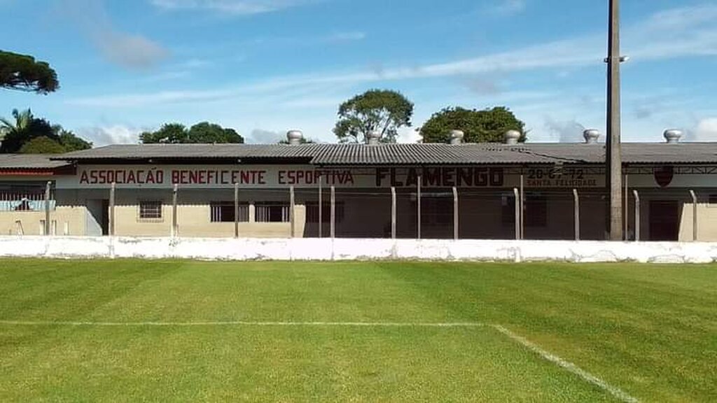 Campo de futebol americano da Associação Beneficente Esportiva Flamengo durante dia de sol.