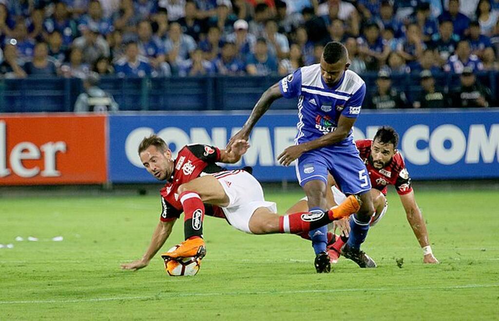 Everton Ribeiro, quando jogava pelo Flamengo, disputando uma bola contra um jogador adversário