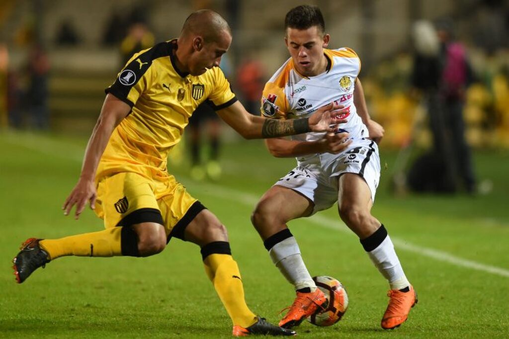 Jogadores do The strongest e peñarol se enfrentando em campo