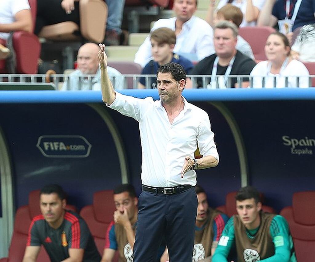 Imagem do ex zagueiro fernando hierro atuando como técnico, em campo, com o time reserva atrás