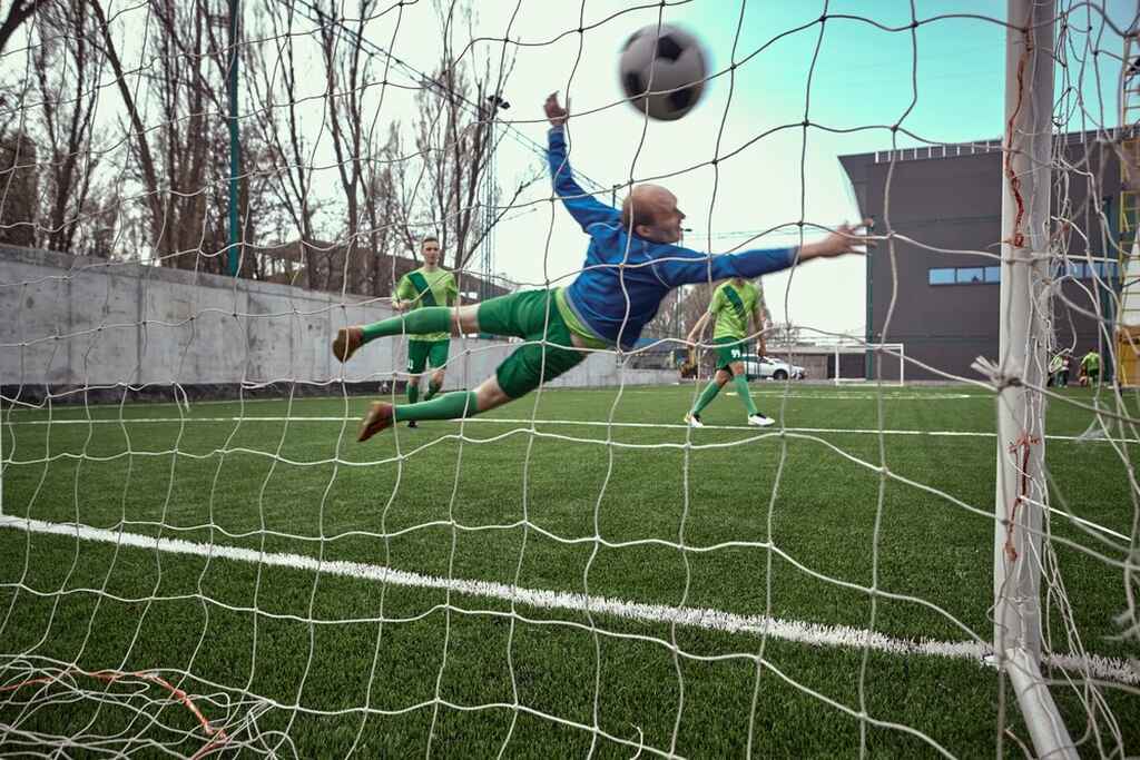 Jogador de futebol fazendo um gol por pênalti