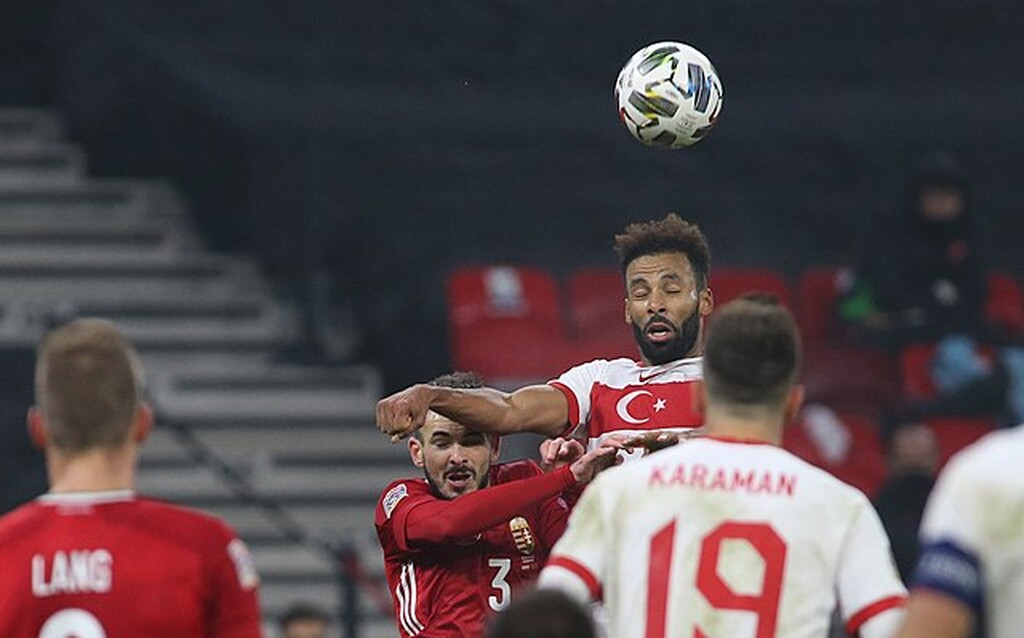 jogador da turquia, que sabe como apostar em um gol de cabeça, cabeceia a bola em campo