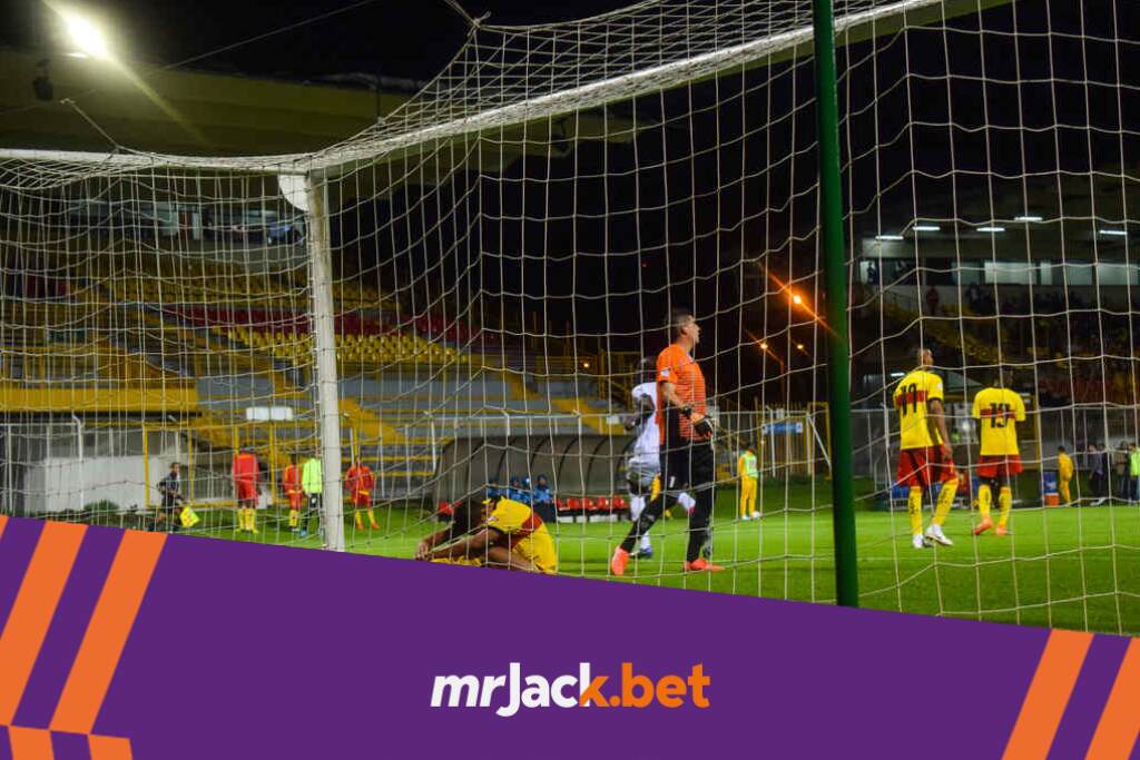 Vista por trás do gol dos jogadores vestido de amarelo cabisbaixo após o adversário marcar.