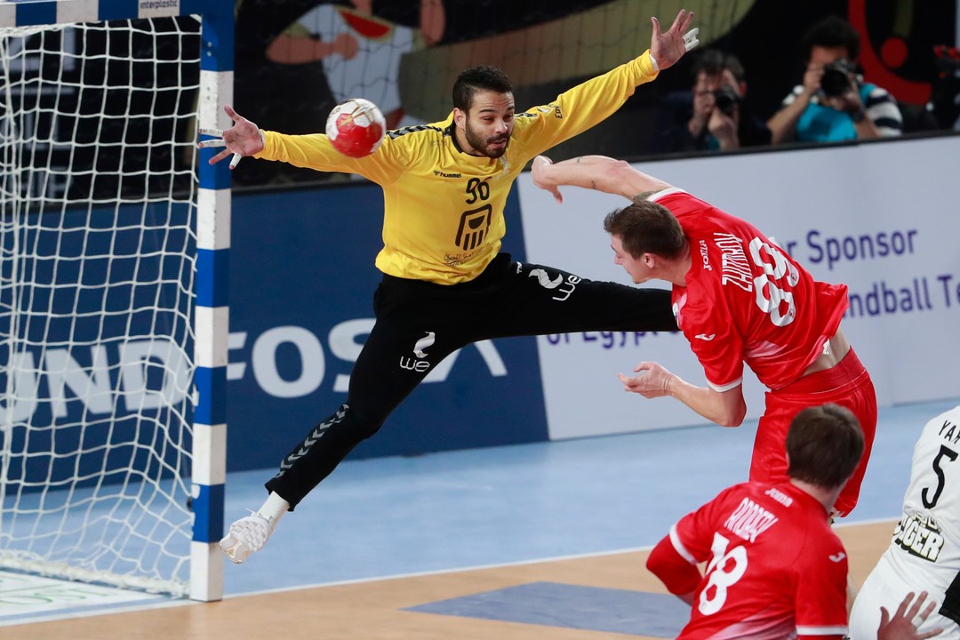 Jogador de handebol arremessando uma bola para o gol 