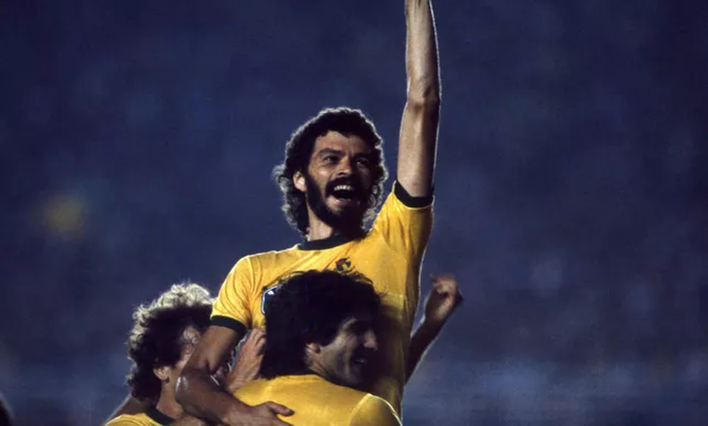 socrates, um dos capitaes da seleção brasileira, comemorando o titulo em campo sendo carregado pelo elenco