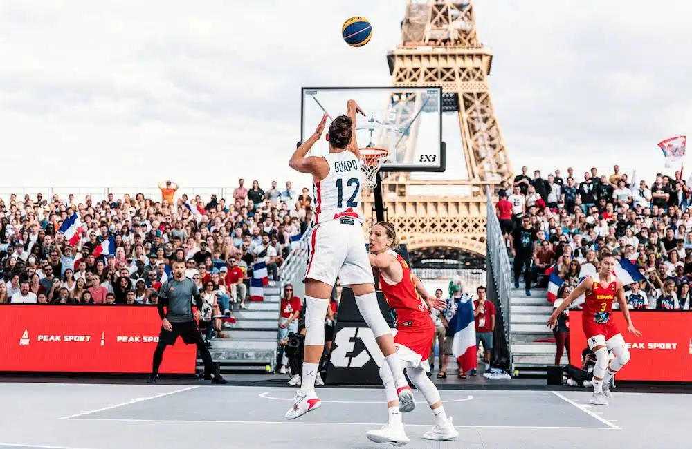 Jogador de basquete jogando em frente a Torre Eiffel