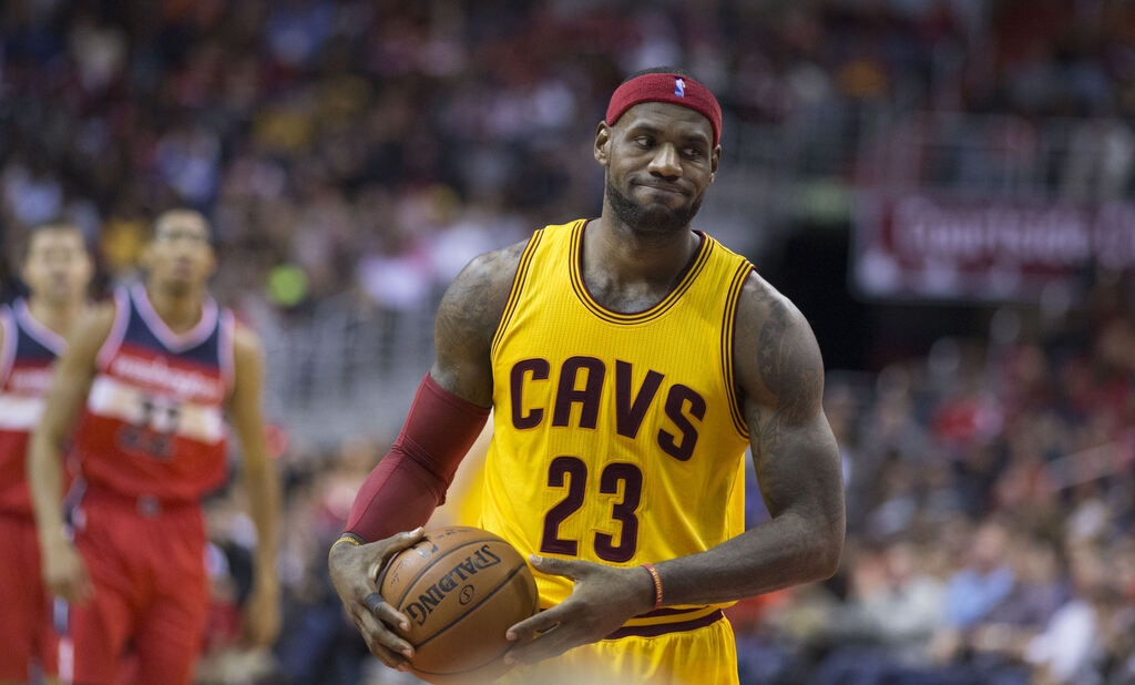 Jogador de basquete LeBron James com uniforme amarelo e faixa vermelha na cabeça.