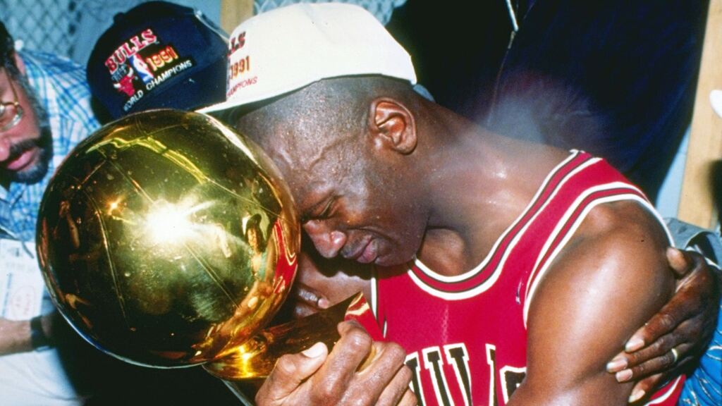 michael jordan chorando e abraçado ao troféu da nba, que marcou a historia do chicago bulls