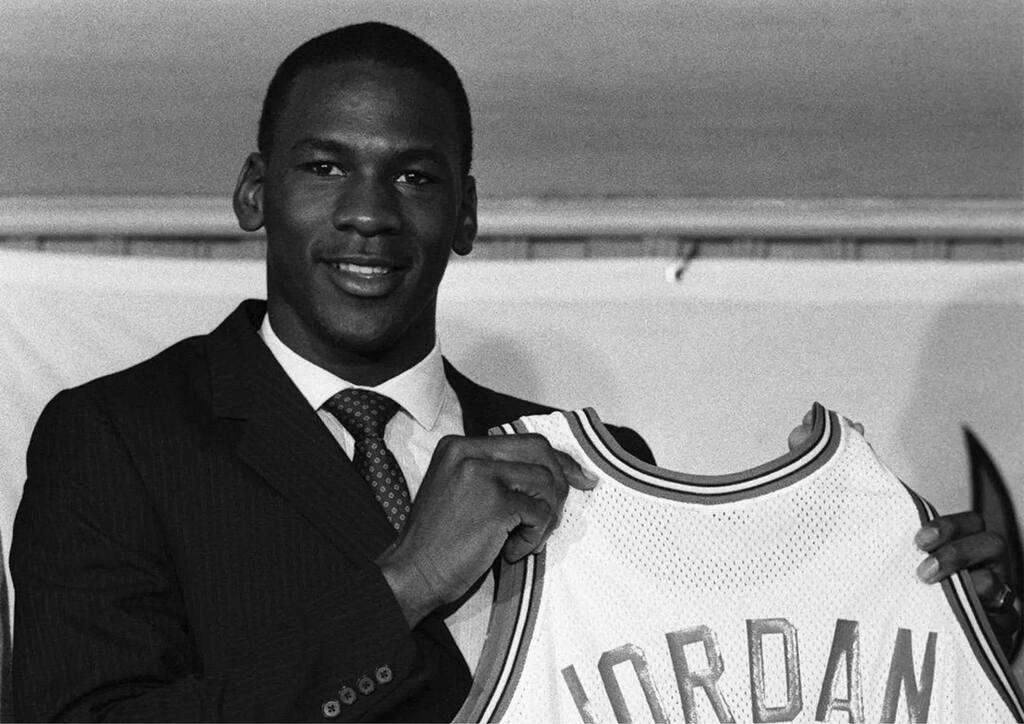 michael jordan segurando a jersey do bulls, prestes a se tornar o maior idolo da historia do chicago bulls