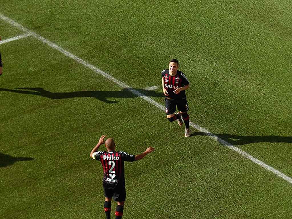 Jogador do Athlético Paranaense deixando o campo, enquanto outro se prepara para entrar em seu lugar.