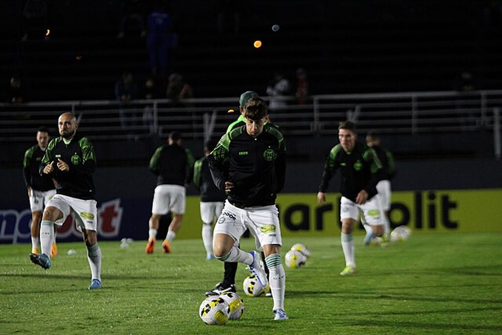 Jogadores do Coritiba vestindo agasalhos do time durante treino no frio.