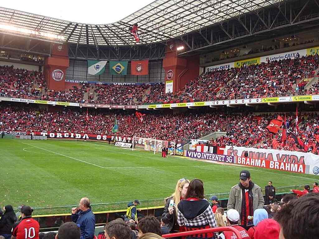 Estádio lotado, com as arquibancadas cheias de torcedores do Furacão, vestindo seu uniforme vermelho e preto.