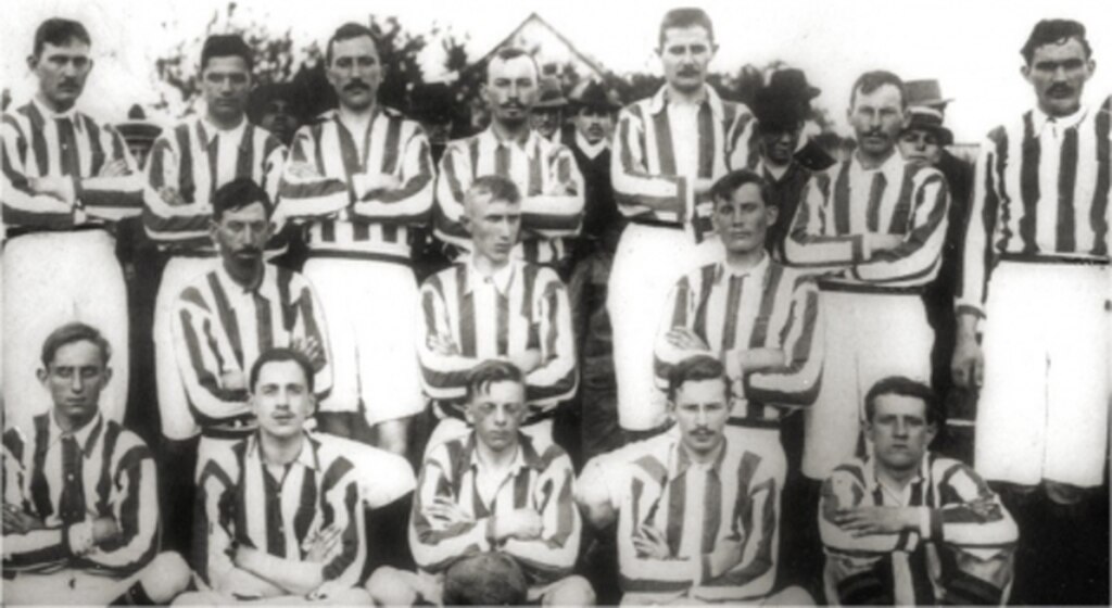 Equipe antiga do Coritiba vestindo uniforme listrado antes da partida começar, em preto e branco.