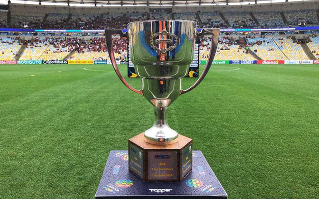 Taça Guanabara exposta em cima de um púlpito, no gramado de um estádio, antes de uma decisão de título.