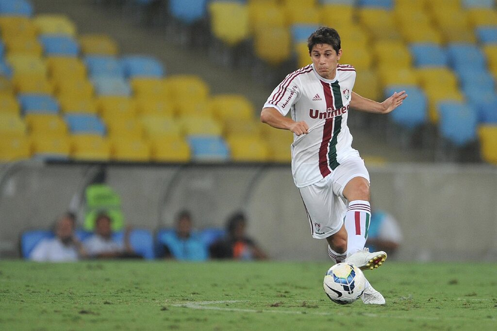 Darío Conca, jogador de futebol, quando jogava pelo Fluminense, conduzindo a bola em campo durante partida de futebol.