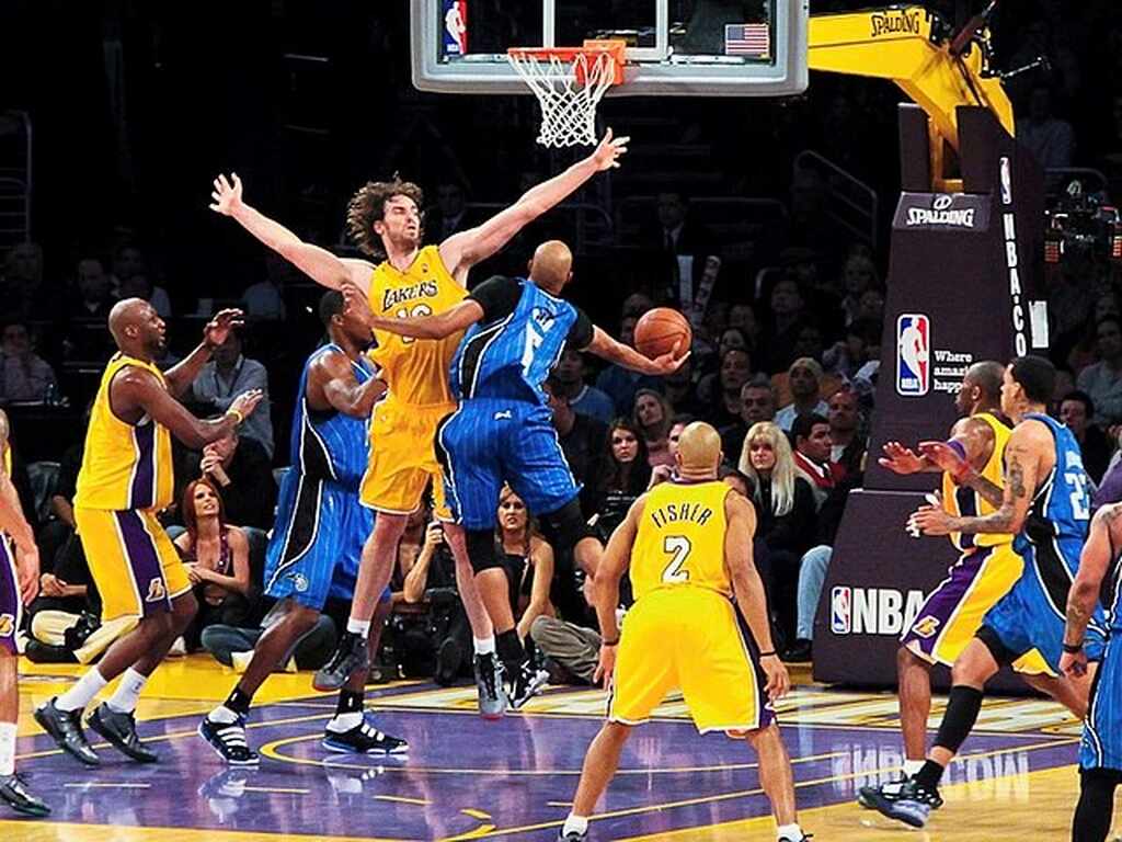 Jogador do Los Angeles Lakers salta para bloquear tentativa de cesta do adversário, durante partida de basquete pela NBA.