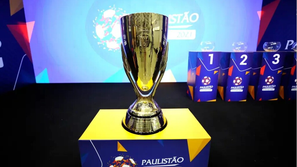 Taça do Campeonato Paulista sobre um púlpito e diante de um telão com o logo da competição.