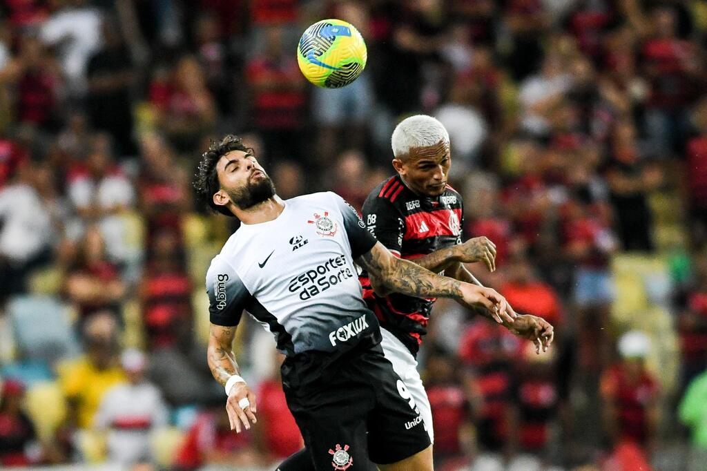 jogadores do corinthians e flamengo se disputando em campo. o rubro-negro costuma ser o time a fazer o primeiro gol