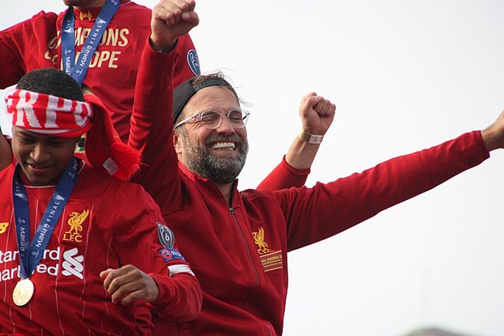 Técnico do Liverpool, Jürgen Klopp, comemorando uma conquista com o tradicional uniforme vermelho do clube.