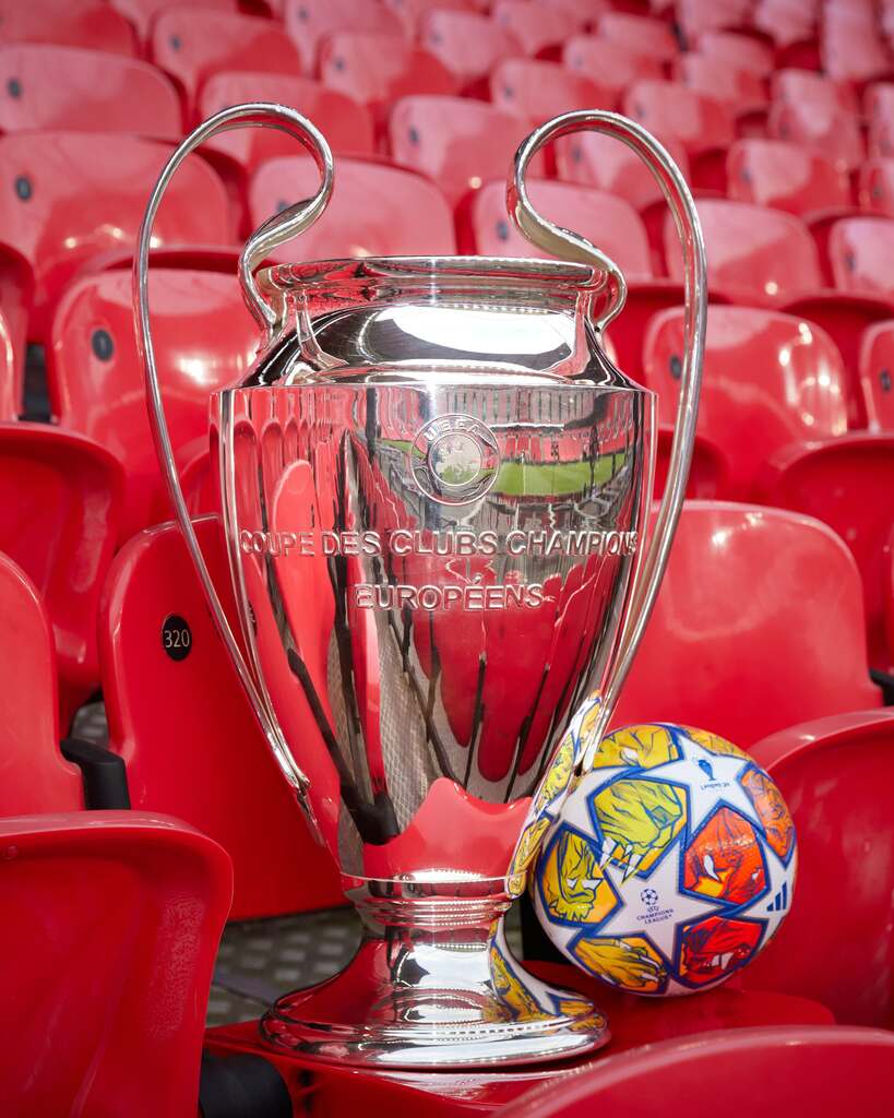 Taça da Champions LEague com a bola oficial do lado na arquibancada do estádio