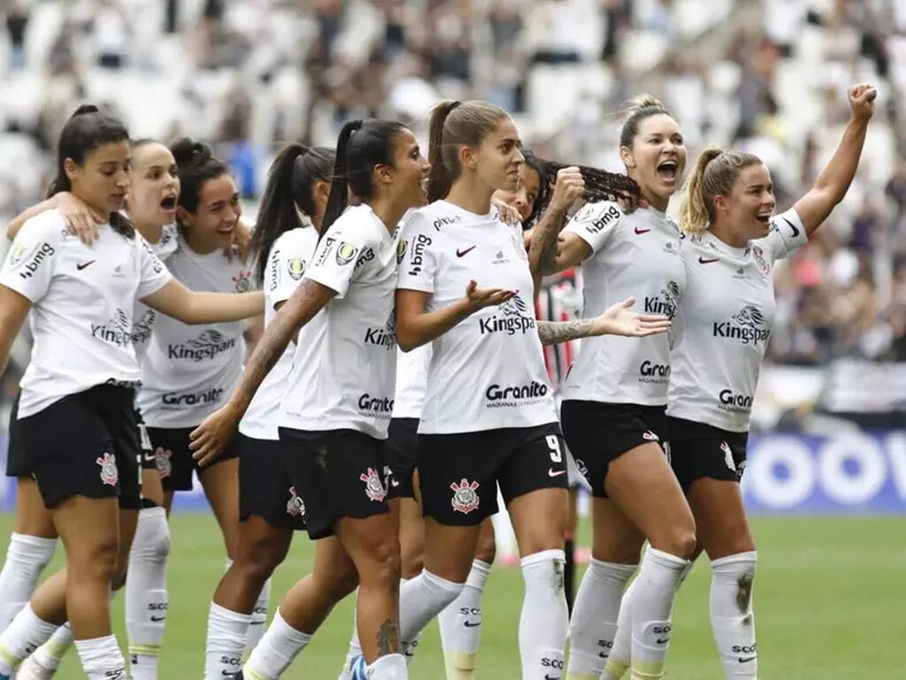 Jogadoras do time de futebol feminino do Corinthians comemorando gol marcado durante partida de futebol.