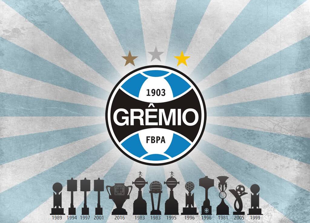 Escudo do Grêmio, em fundo azul com listras brancas, com silhuetas dos troféus já conquistados pelo clube.