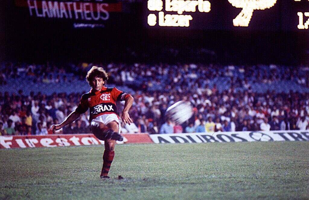 ídolo do Flamengo, Zico, chutando a bola com o pé direito durante partida da equipe.