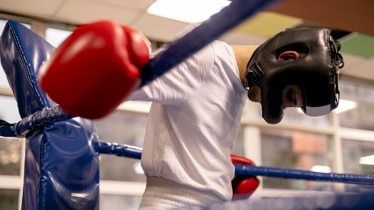 Lutador de boxe de cabeça baixa descansando pós treino