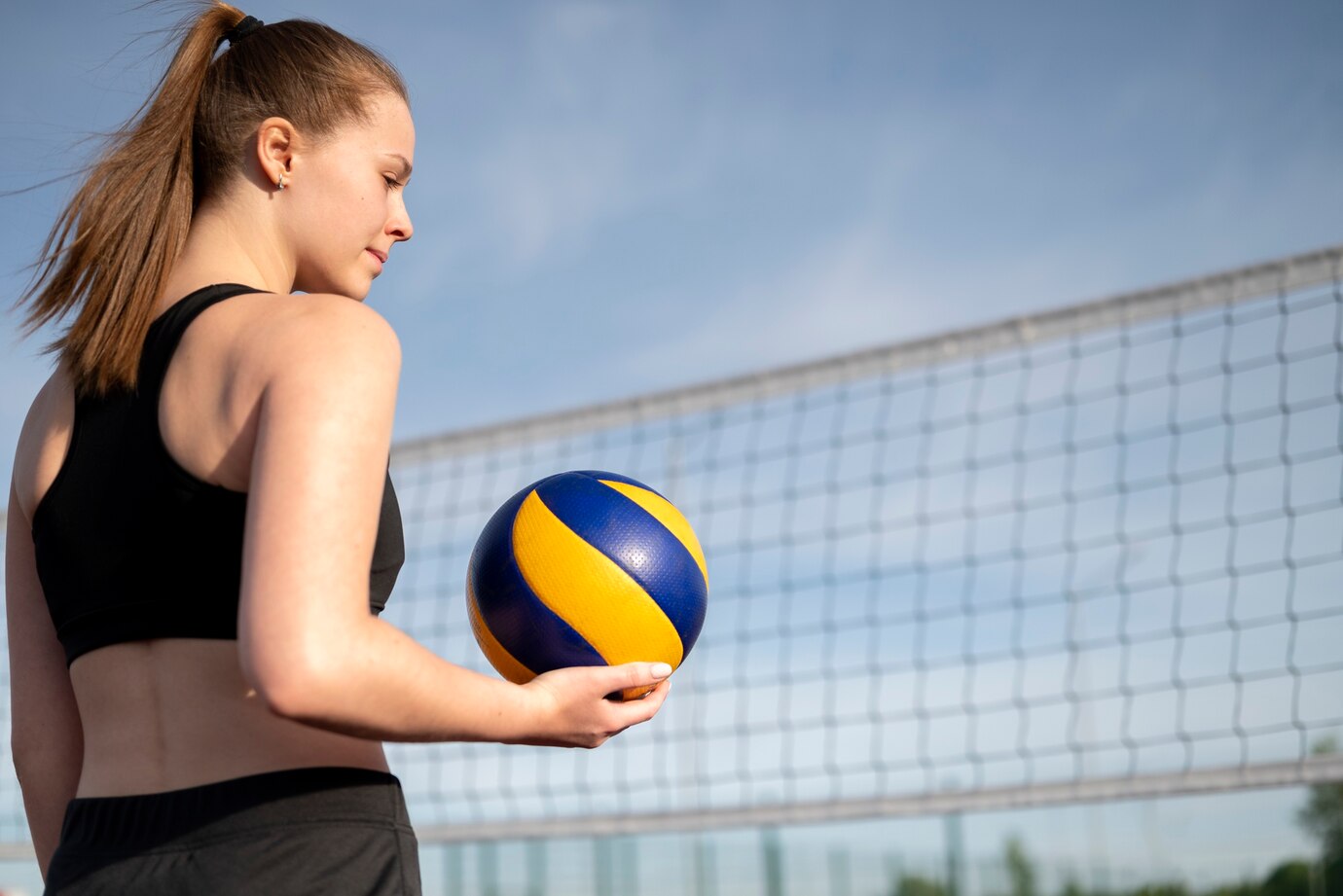 Pessoa segurando uma bola de volei