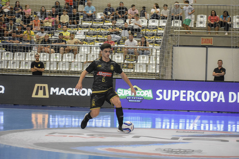 Jogador de futsal do Magnus Sorocaba correndo em quadra com a bola dominada