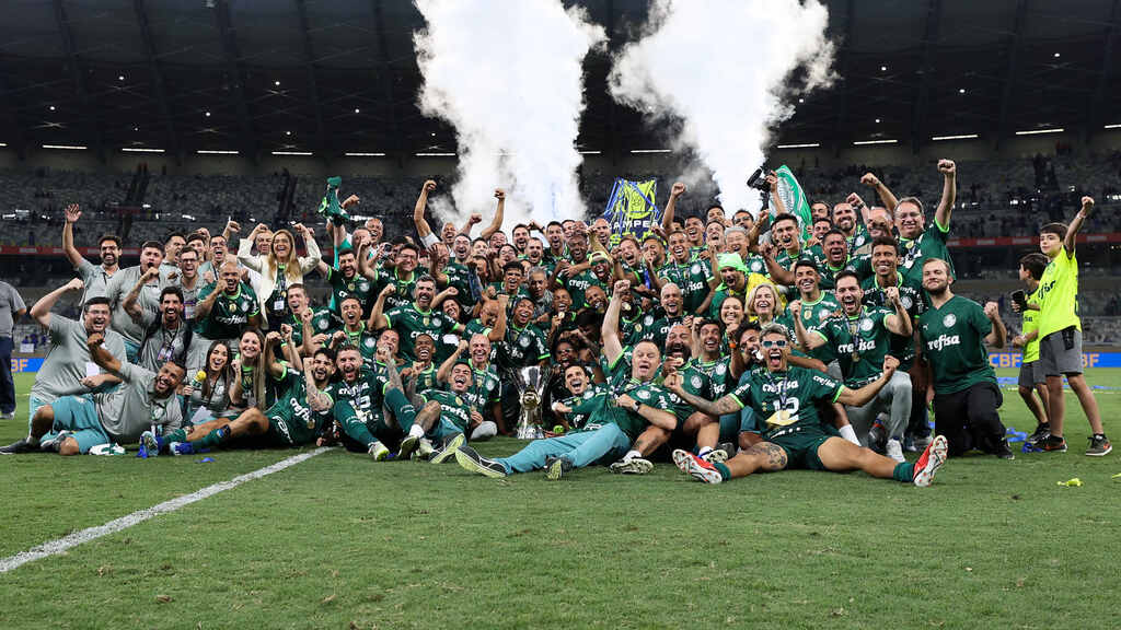 Jogadores do Palmeiras comemorando título do brasileirão no gramado do estádio.