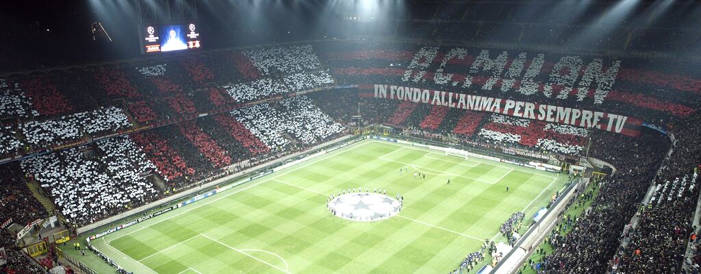 Estádio San Siro do Milan, visto do topo da arquibancada, com visão para todo o campo e torcida da equipe.