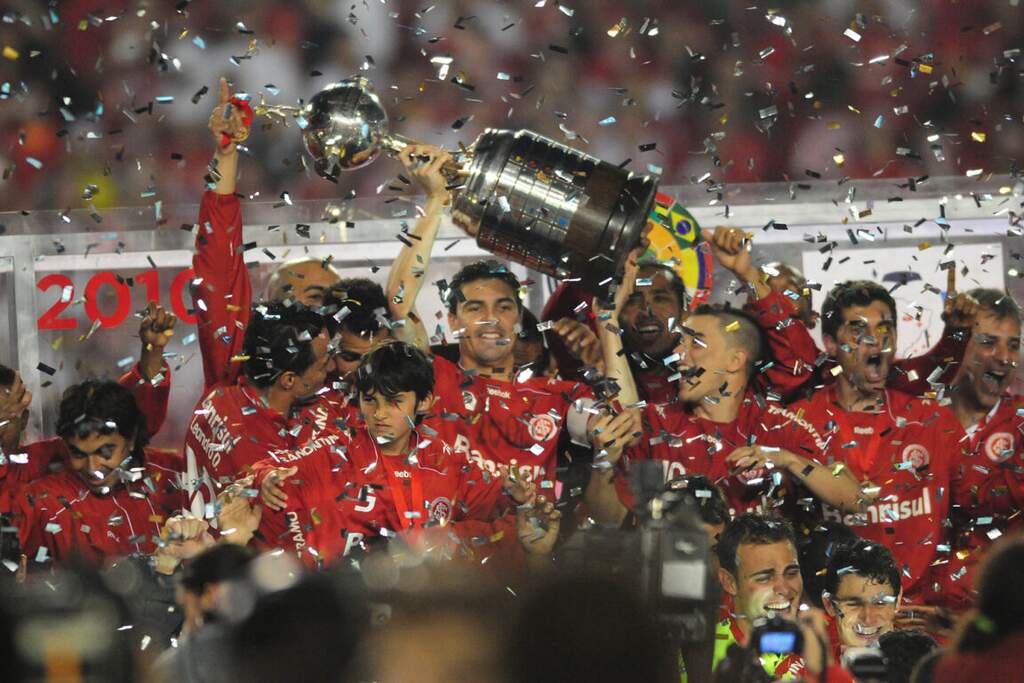 Time do Internacional de 2010 levantando a taça da Libertadores e comemorando o título.