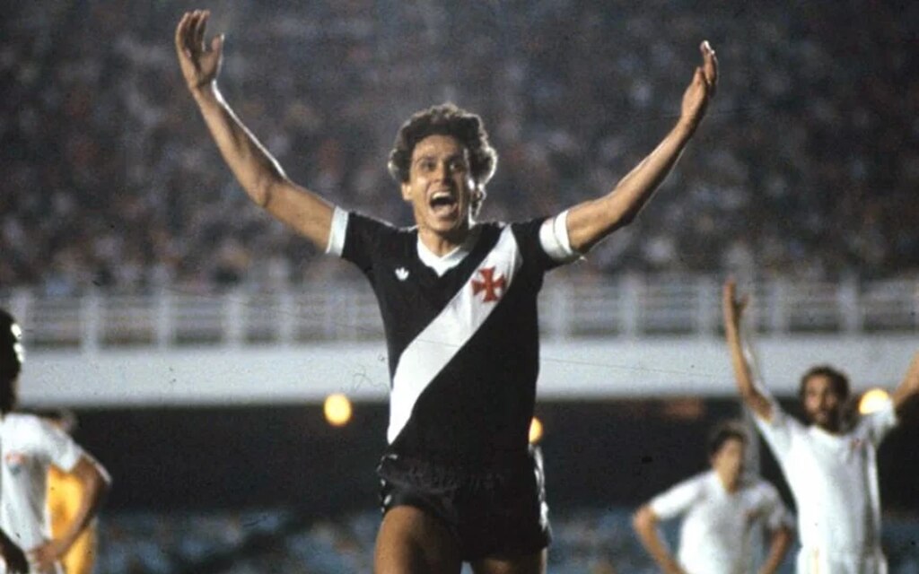 Ex-jogador do Vasco, ídolo do clube, Roberto Dinamite, correndo com os braços abertos em comemoração ao gol.