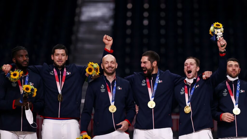 Jogadores da seleção francesa de handebol, comemorando e utilizando medalhas de oura das olimpíadas.