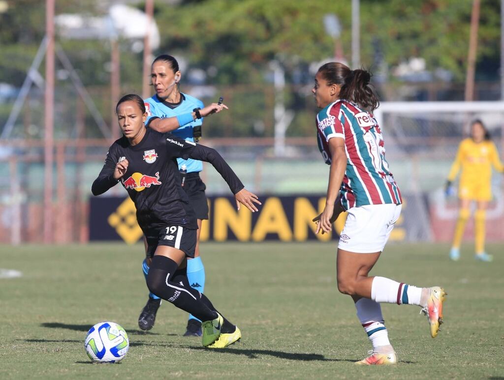 Jogadora do RB Bragantino vestindo uniforme preto e conduzindo a bola durante partida de futebol.