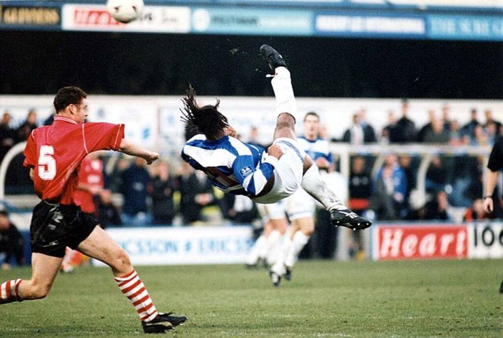 Gol de bicicleta do jogador Trevor Sinclair, vestindo uniforme branco e azul, durante jogo da FA Cup de 1997.