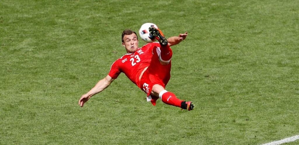 Gol de bicicleta do jogador Xherdan Shaqiri, usando uniforme vermelho da Polônia em jogo da Eurocopa de 2016.