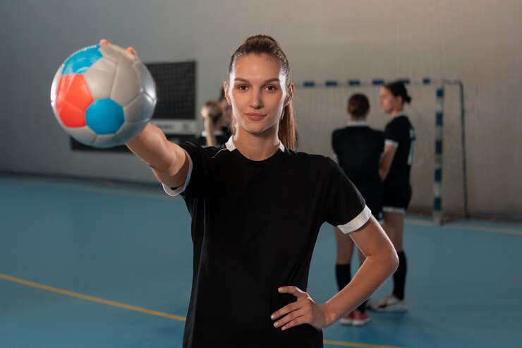 Jogadora de Handebol segurando a bola do jogo em uma mão