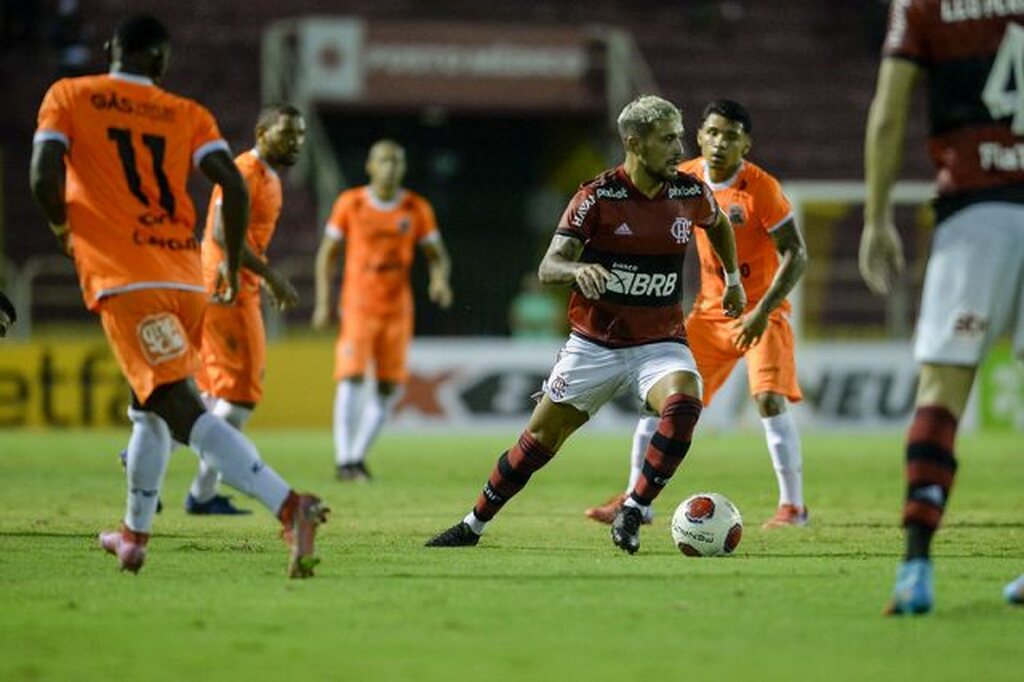 Jogadores de Nova Iguaçu e Flamengo disputando bola em campo