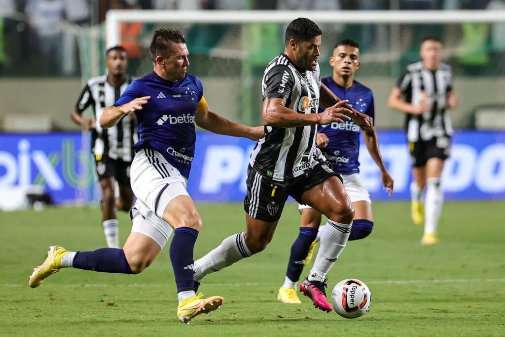 Jogadores de Cruzeiro e Atlético-MG disputando bola em campo