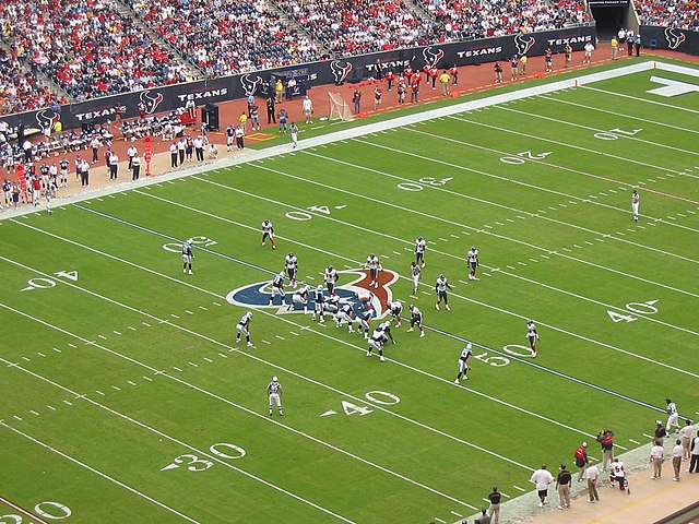 Campo de futebol americano acontecendo um jogo