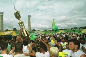 Jogadores e torcedores levantando uma taça de campeão do cuiaba 