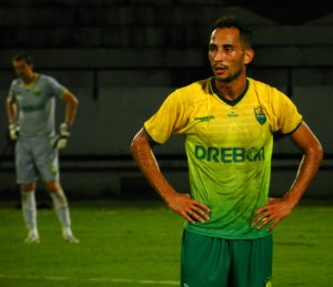 Jogador do cuiaba com as mãos na cintura em campo 