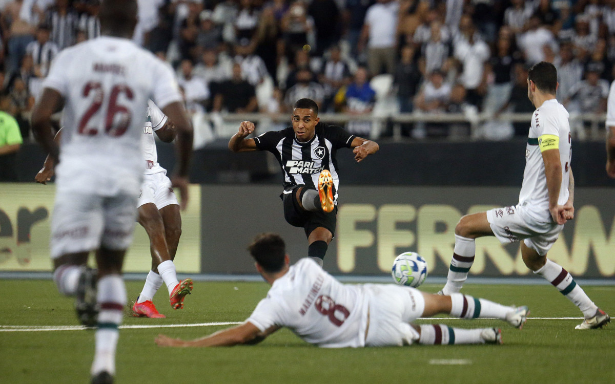 Jogador dando um carrinho em uma disputa de bola com um jogador do Botafogo - Vitor Silva/ Botafogo