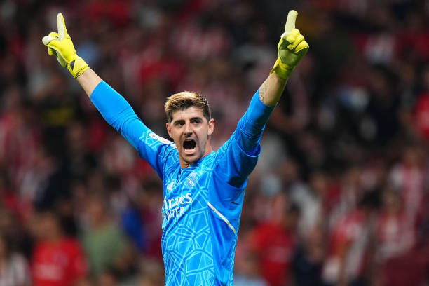 Goleiro do Real Madrid comemorando com os braços para o alto 