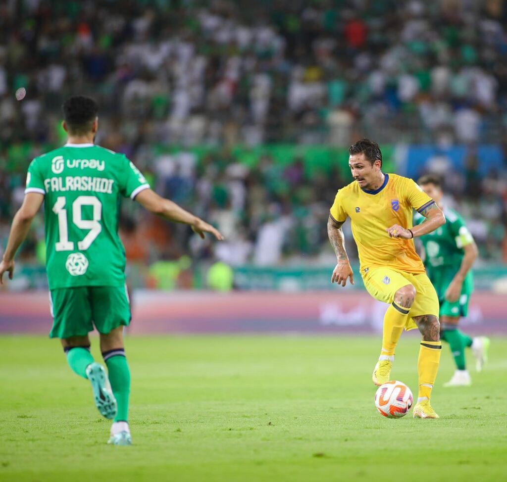 Jogador brasileiro Vina, vestindo uniforme amarelo do Al-Hazem durante partida de futebol.